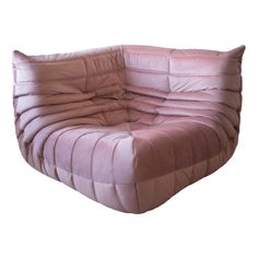 a pink couch sitting on top of a white floor