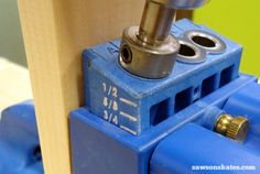 a drill is being used to make a hole in the side of a wooden box