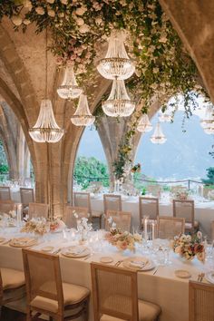 a table set up with flowers and chandeliers