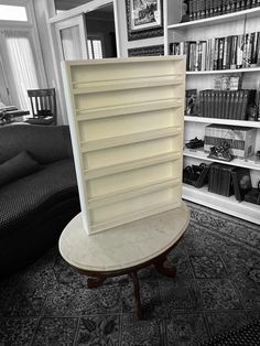 a book shelf sitting in the middle of a living room