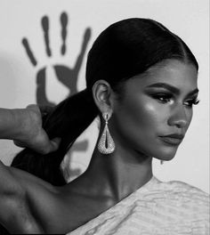 a woman with long hair wearing large earrings