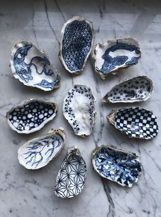 nine blue and white bowls sitting on top of a marble table