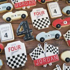 decorated cookies with race cars and numbers are displayed on a wooden table for the four year anniversary celebration