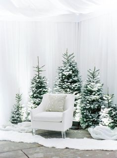 a white chair sitting in front of christmas trees