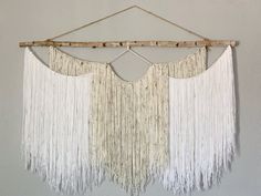 a wall hanging with white fringes on it