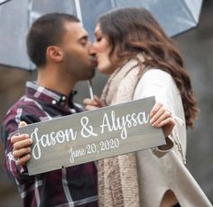 a man and woman kissing while holding an umbrella in front of their face with the sign that says, mason & alyssa june 20, 2020