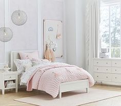 a bedroom with white furniture and pink bedding