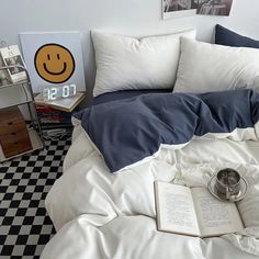 an unmade bed with white sheets and blue pillow cases on top of it in a bedroom