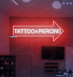 a neon sign that says tattoo piercing on the side of a wall in a store