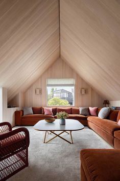 a living room filled with lots of furniture and a large wooden ceiling over the couches