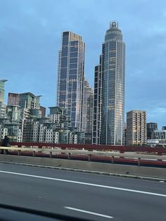 the city skyline is seen from across the highway in this photo, with tall buildings on either side