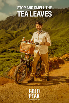 a man standing next to a bike on a dirt road