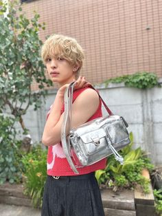 a young woman is carrying a silver purse