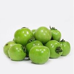 a pile of green apples sitting next to each other on top of a white surface