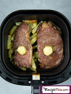 two steaks with potatoes and green beans in an air fryer