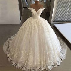 a wedding dress on display in front of a mirror