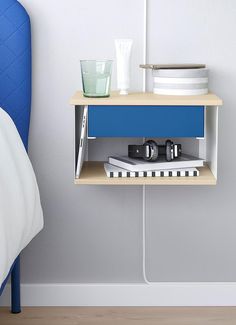 a blue and white shelf next to a bed