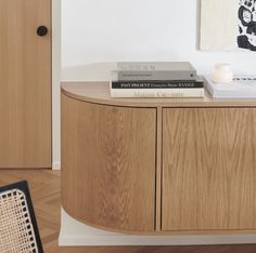 two books are sitting on top of a wooden cabinet