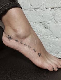 a woman's foot with an arrow and stars tattoo on the bottom of it