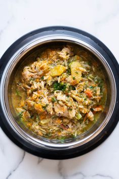 a close up of a bowl of food on a table with a marble counter top