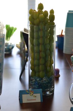 there is a glass vase with grapes in it