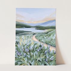 a painting on a white wall with green and blue flowers in front of a body of water