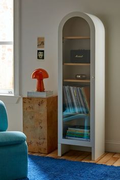 a room with a blue chair and a book shelf