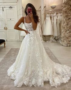 a woman taking a selfie in her wedding dress while looking at her cell phone