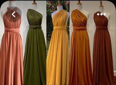 four different colored dresses on mannequins with flowers in the back ground behind them