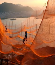 some people are walking on the beach with orange nets