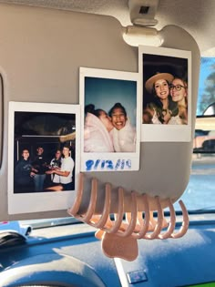 some pictures hanging on the side of a car with clothes pins attached to it's hooks