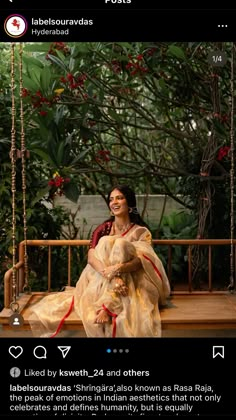 a woman is sitting on a swing in the middle of some trees and smiling at someone