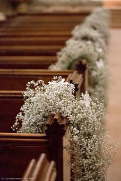 baby's breath flowers line the pews of a church