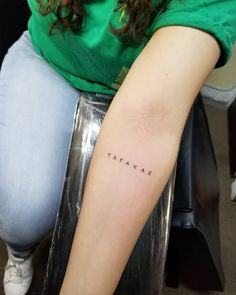 a woman with a small tattoo on her arm that says, tame in cursive writing