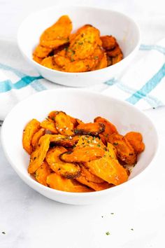 two white bowls filled with food on top of a table