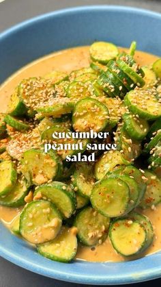 a blue bowl filled with cucumber and peanut sauce