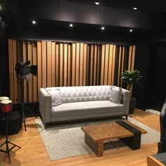 a living room with a couch, coffee table and sound equipment on the wooden floor