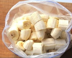 a plastic bag filled with sliced bananas on top of a wooden table