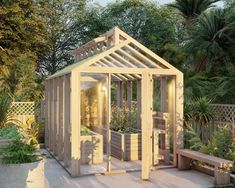 a small wooden greenhouse in the middle of a garden with plants and benches around it