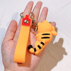 a hand holding a keychain with a cartoon character on it's side