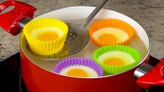 colorful cupcakes are being cooked in a red pot