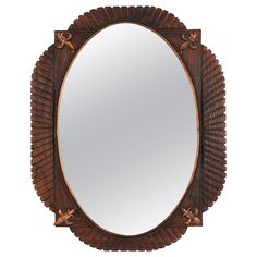 a mirror that is sitting on top of a wooden frame and has an intricate design around it