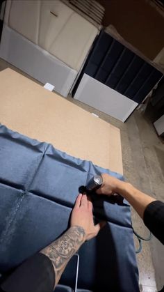 a man laying on top of a blue mat next to another person holding a pair of scissors