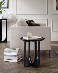 a living room with a couch, coffee table and two books on the floor in front of it