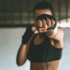 a woman in black bra top holding up her fist