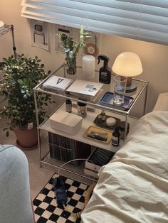 a room with a bed, desk and lamp on it in front of a window