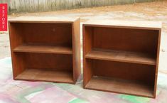 two wooden shelves sitting next to each other on top of a blanket in front of a fence