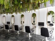 the interior of a salon with chairs and mirrors