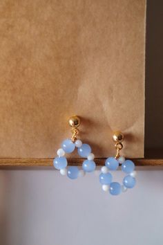 Elevate your ear game with our "Petals Hoop" earrings, meticulously handcrafted with alternating blue and white beads, reminiscent of delicate flower petals. These earrings are the epitome of elegance and sophistication, adding a touch of charm to any outfit. ✿ Details ✿ - Each hoop is meticulously handcrafted using high-quality blue and white beads, ensuring durability and timeless elegance. - Perfect for office wear, commuting, and urban style, these earrings add a sophisticated touch to any o Dangly Beaded Earrings, Blue Round Bead Hoop Earrings Gift, Blue Hoop Earrings With Round Beads As Gift, Blue Hoop Earrings With Dangling Beads Gift, Cute Bead Earrings, Hoop Earrings With Beads, Flower Bead Earrings, White Beaded Earrings, Diy Earrings Easy