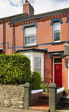 a brick house with red door and windows